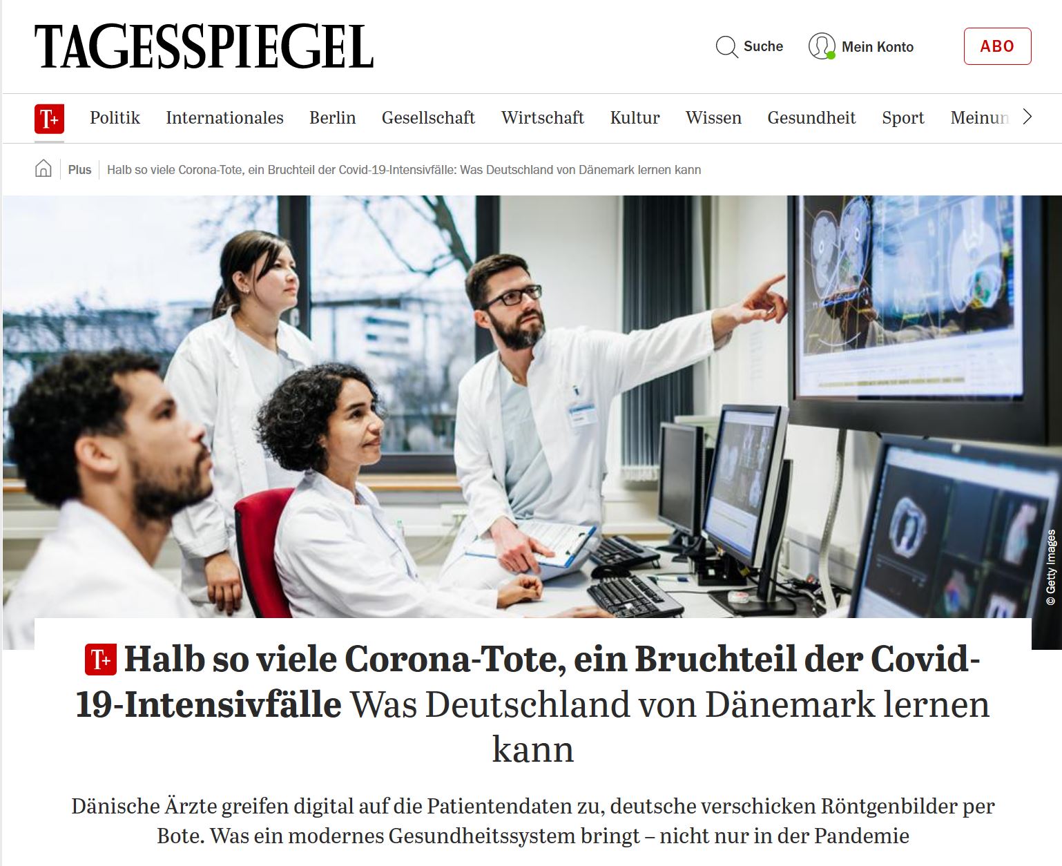 Andere Bildsprache: Ein Mann mit einem Baby im Tragetuch spült Geschirr in der Küche
