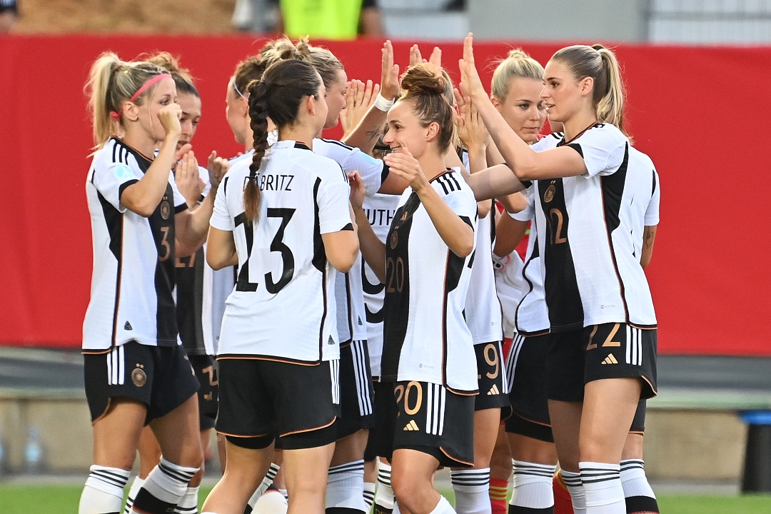 10 Frauen des deutschen Nationalteam in weiß-schwarzen Trikots klatschen sich vor Spielbeginn motivierend ab