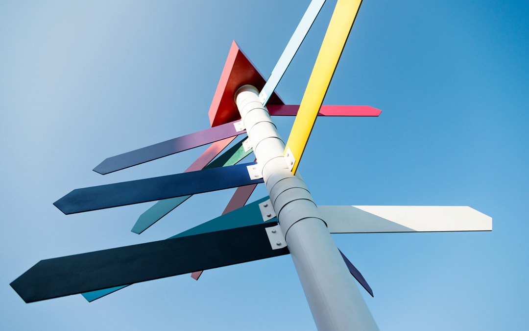 Bunte Wegweiser von unten gegen den blauen Himmel fotografiert