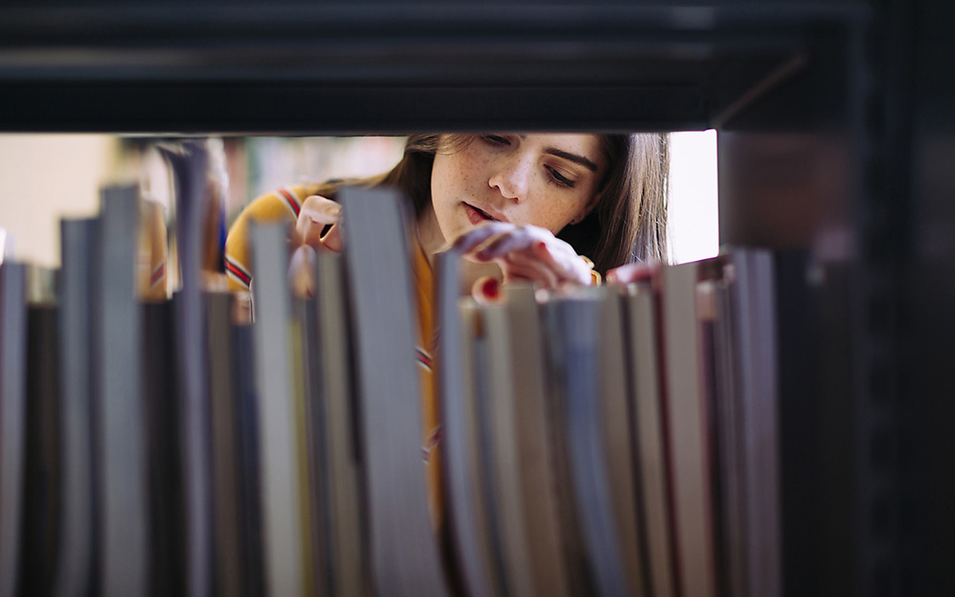 Frau hinter Bücherregal