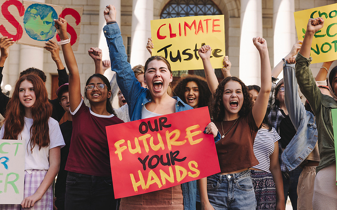 „Fridays for Future“- Demo: Zehn Mädchen stehen mit Schildern da und recken die Fäuste