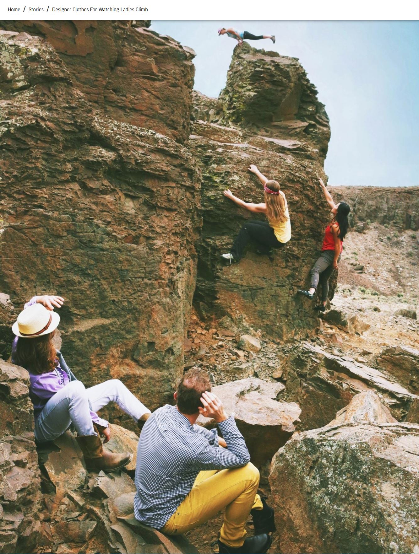 Drei Frauen in Sportkleidung klettern an einem Felsen, zwei Männer, nicht sportlich gekleidet, schauen zu