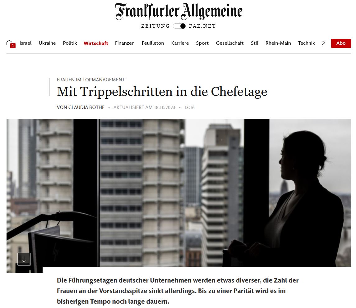 Frau steht im Gegenlicht eines Büros und schaut auf die Skyline mit Hochhäusern