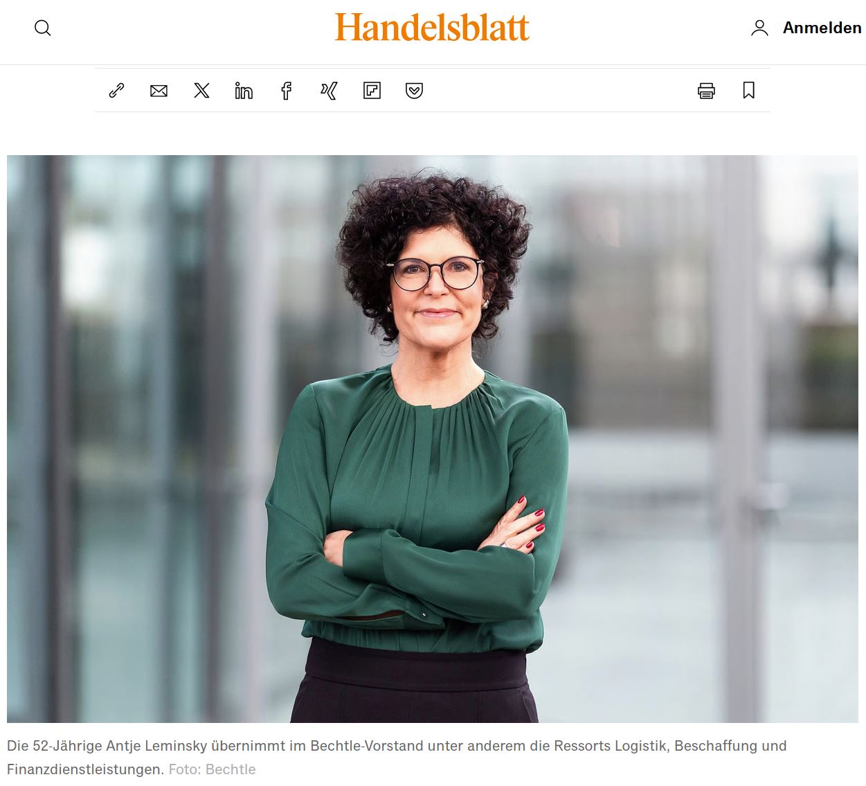 Blonde Frau, schwarzer Blazer, blauer Schal mit verschränkten Armen