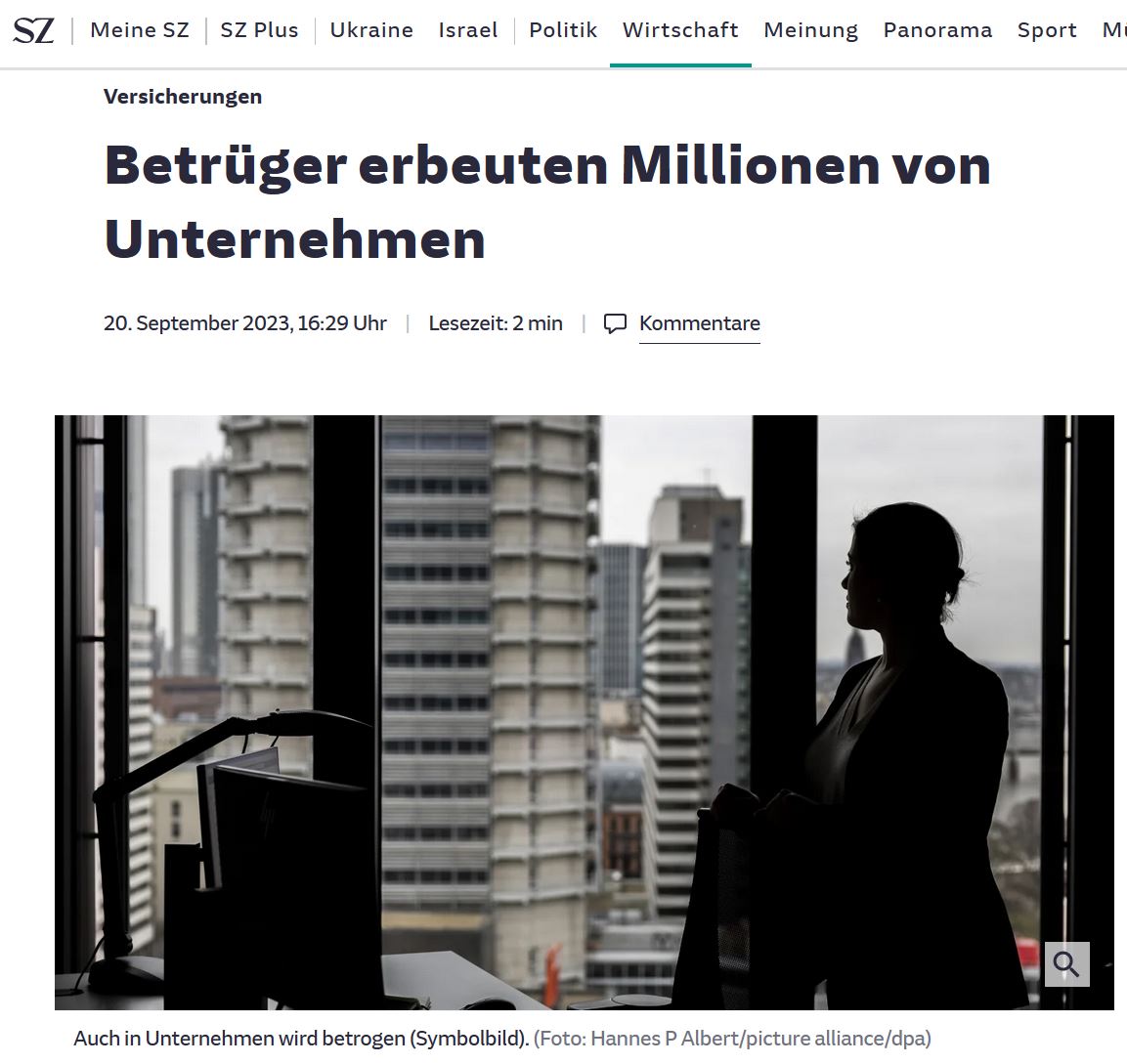 Frau steht im Gegenlicht eines Büros und schaut auf die Skyline mit Hochhäusern