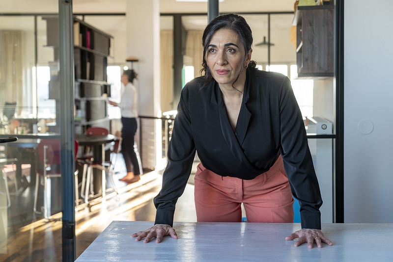 Chefin fordert Entscheidung ©Anita Back Frau in dunkler Bluse stützt sich herausfordernd auf einen Tisch