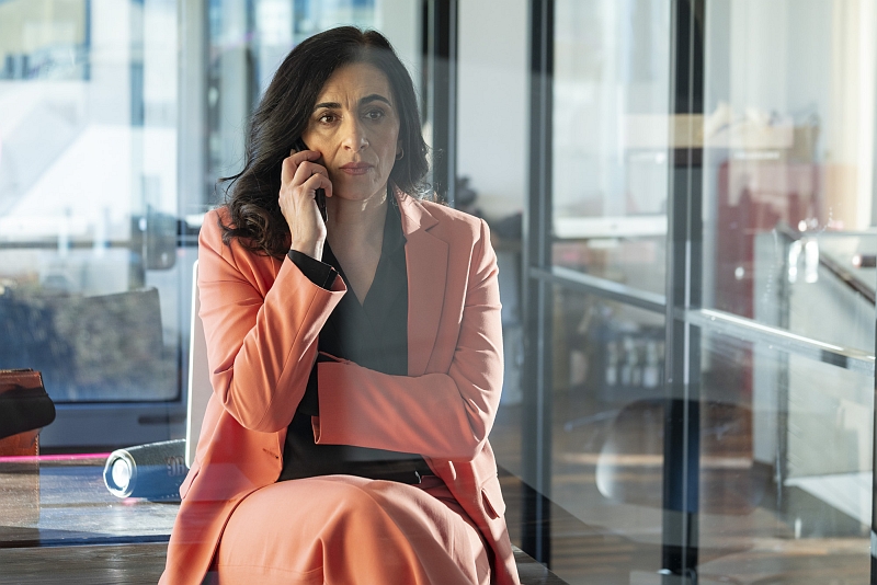 Chefin telefoniert ©Anita Back Dunkelhaarige Frau im rosa Hosenanzug sitzt und telefoniert