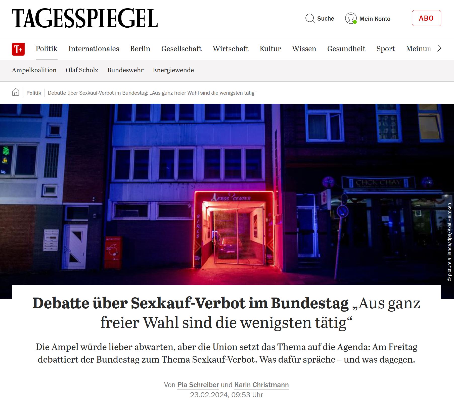 Häuserzeile am Abend. rot beleuchtet ist der Eingang zu einem Eros Center.