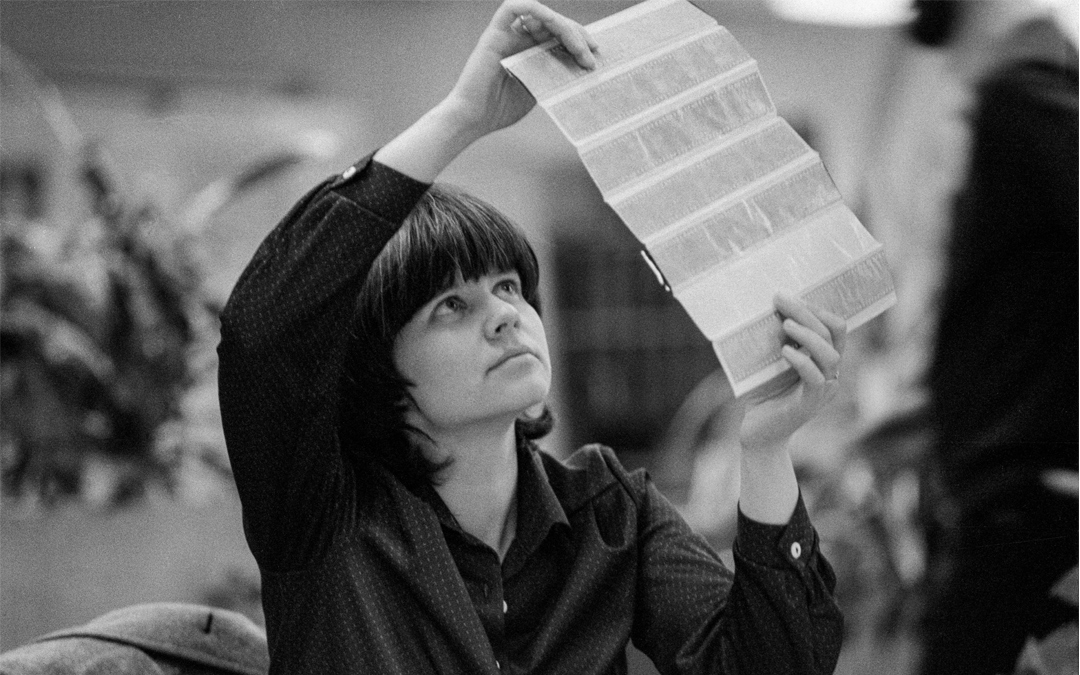 Gabriele-Senft_1983-ADN_DDR-Fotoerbe Fotografin hält Negativbogen gegen das Licht