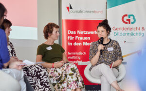 Zwei Frauen diskutieren auf einem Podium